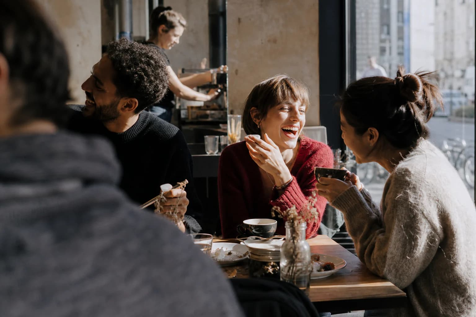 Gäste lachen und essen gemeinsam an einem Tisch