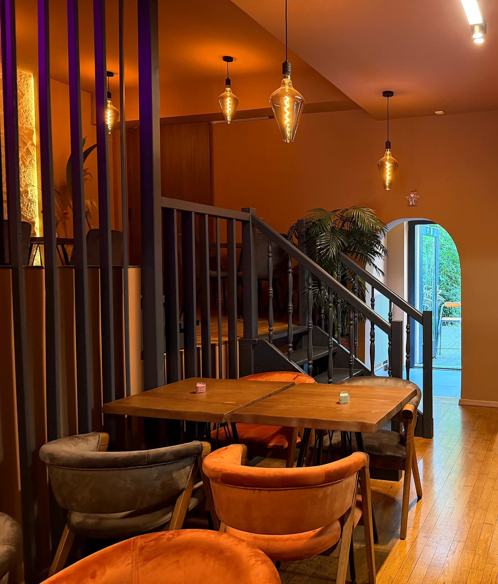Stairs to the gallery and an arched passage, the open kitchen with green cladding on the right